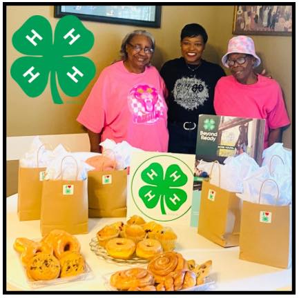 4-H Emblem logo. Three women posing for a photo.